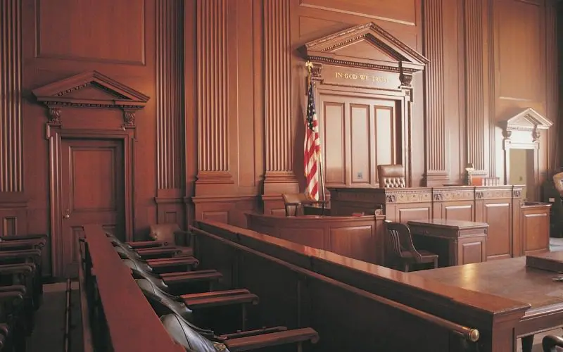 A courtroom with the judge 's bench and the american flag.